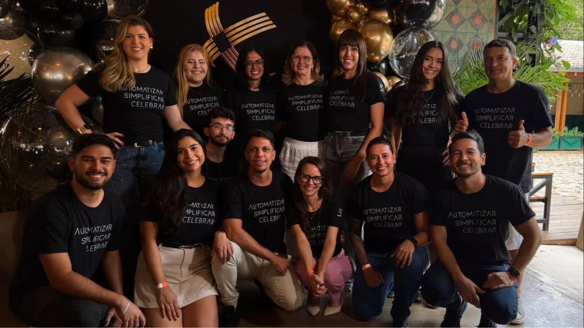 Equipe da Automatize Projetos reunida, com camisetas pretas escritas Automatizar, Simplificar, Celebrar